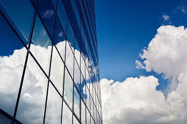istock Dark blue office building glass facade with reflecting clouds 506694957