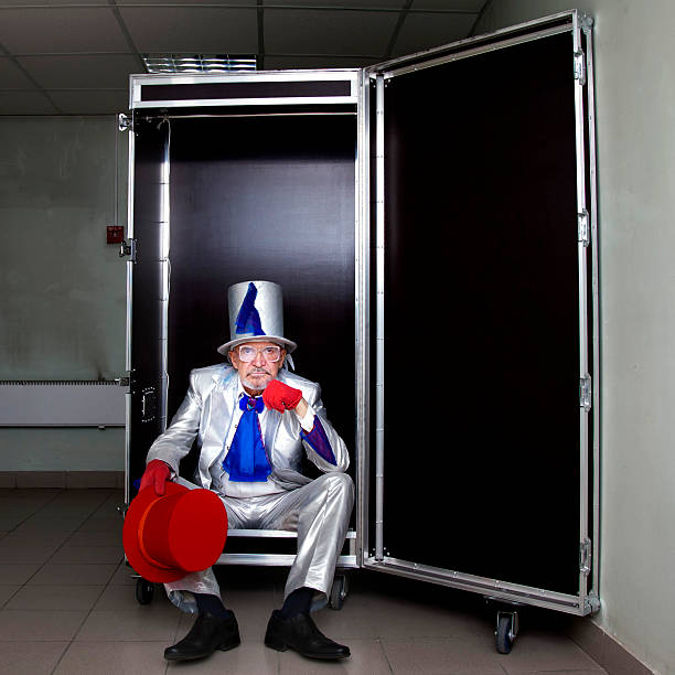 Magician sitting in a box Magician in a white suit with hat sitting in a box before the show pantomime dame stock pictures, royalty-free photos & images