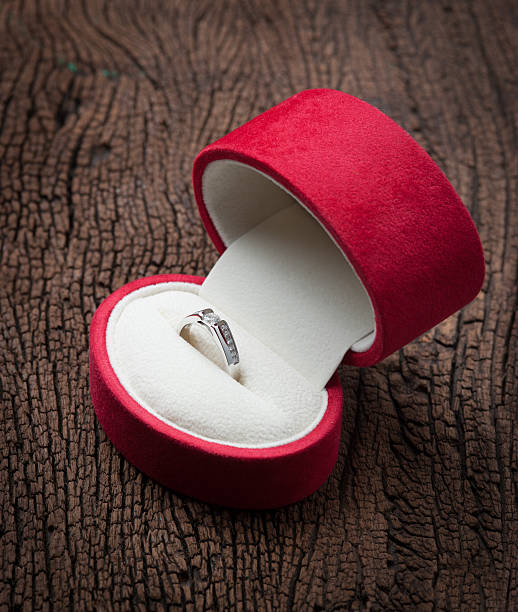 istock Diamond ring in red velvet box on wood 506700450