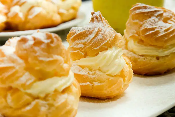 Close up of a cream puff on a white table. Selective focus