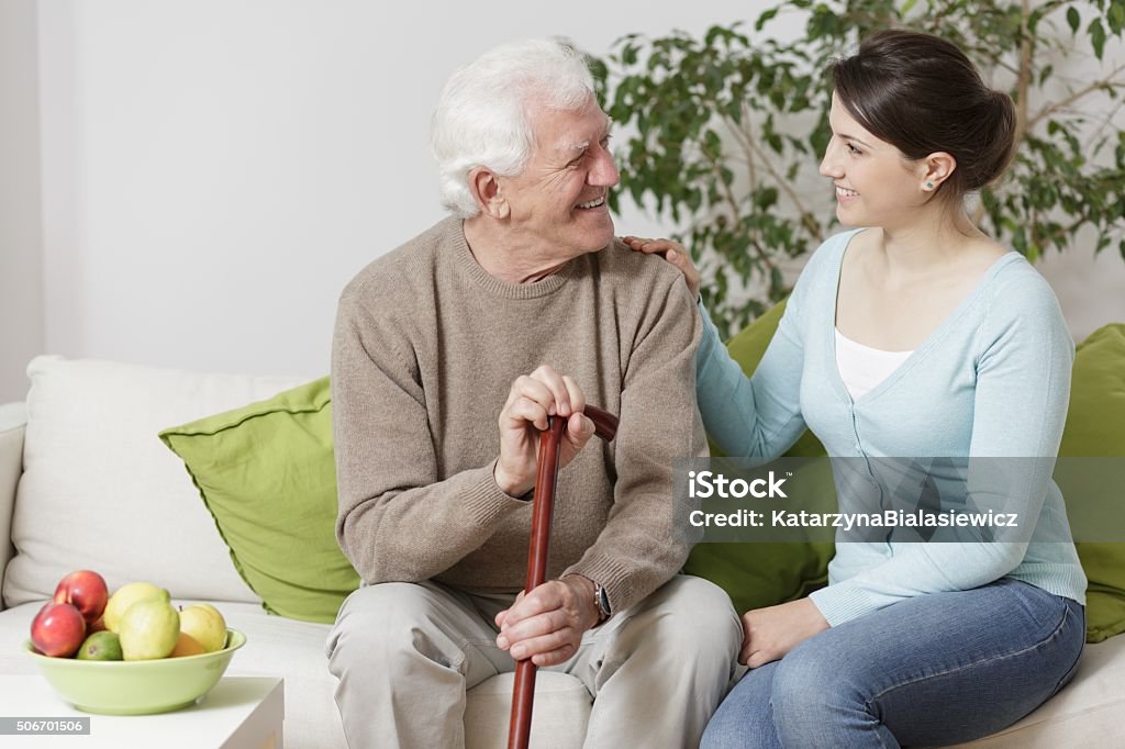 Old man holding a cane Old man holding a cane and smiling to young woman Community Outreach Stock Photo