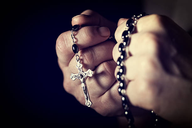 hands and rosary closeup image of hands and rosary rosary beads stock pictures, royalty-free photos & images