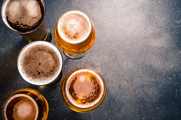 cerveza en vasos sobre una mesa de oscuridad - beer beer glass drink alcohol fotografías e imágenes de stock