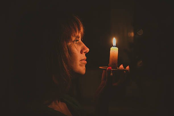 She shines a candle in a dark room
