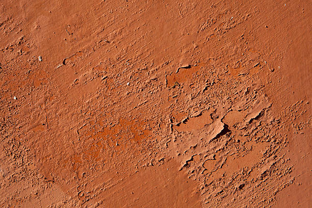 istock Old terracotta painted stucco wall with chipped paint. Backgroun 506706864