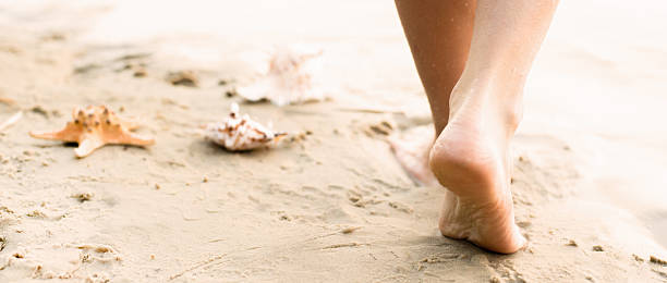 Beach travel - woman walking stock photo