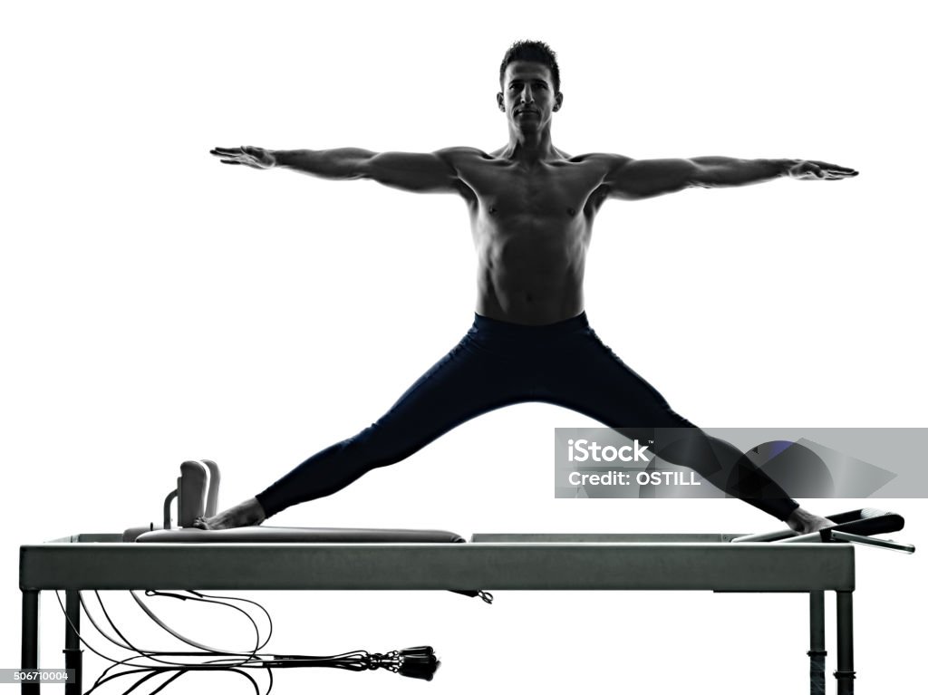 man pilates reformer exercises fitness isolated one caucasian man exercising pilates reformer exercises fitness in silhouette isolated on white backgound Pilates Stock Photo