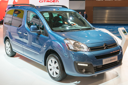 Brussels, Belgium - Januari 12, 2016: Blue Citroen Berlingo Multispace MPV front view. The car is on display during the 2016 Brussels Motor Show. The car is displayed on a motor show stand, with lights reflecting off of the body. There are people looking around and other cars on display in the background.