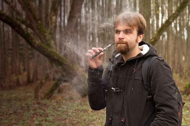 istock man with the electronic cigarette in the park autumn 506713953