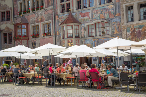 Stein Am Rhein, Switherland - August 6, 2014: People fill an  outdoor cafe at lunch time in the small Swiss village of Stein Am Rhein known for its ellaborately painted buildings.