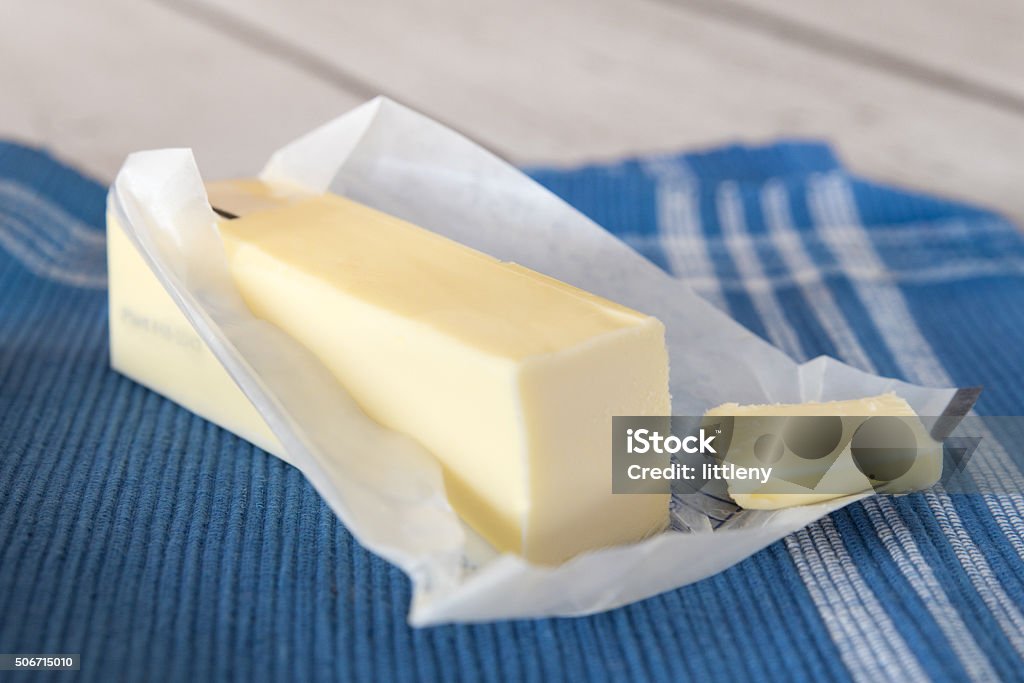 Butter Stick of unwrapped butter on blue cloth Butter Stock Photo