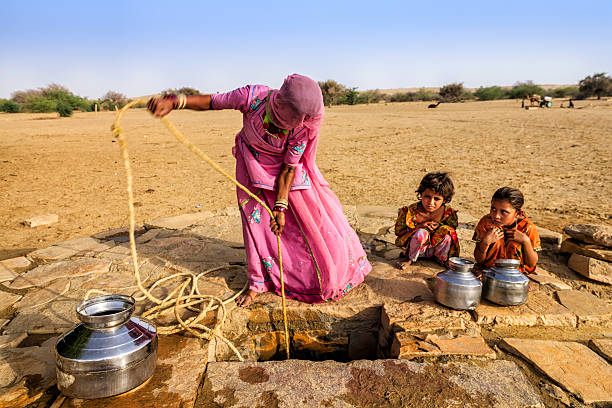 indian femme dessin de l'eau et, dans le désert, rajasthan - thar desert photos et images de collection