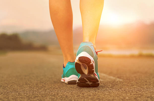 istock Runner athlete feet running on road under sunlight. 506715776