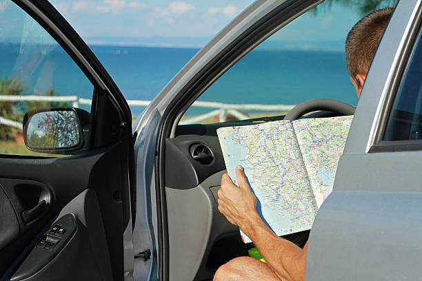 istock Man in  the car and looking at road map. 506716006