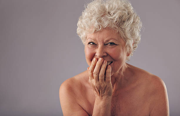 hermosa mujer senior sonriendo - covered nudity fotografías e imágenes de stock