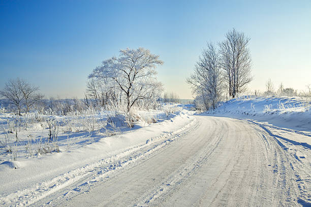 winter landscape with the road  and  blue sky winter landscape with the road, the forest and the blue sky wintry landscape january december landscape stock pictures, royalty-free photos & images