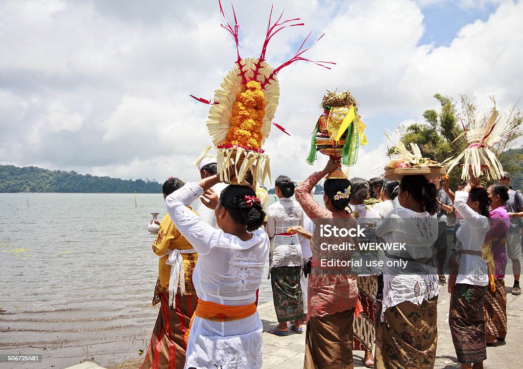 Donna portare offerte e pregare davanti al lago - Foto stock royalty-free di Adulto