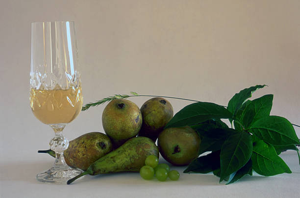 A glass of white wine and fruits isolated on white
