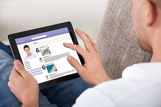 istock Man looking at personal profiles on a tablet 506729683