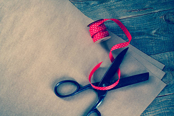 istock Old scissors, red ribbon with white drops and wrapping paper. 506752554