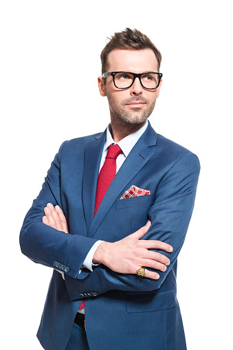 Portrait of elegant CEO wearing elegant suit and nerd glasses, looking away with vision. Studio shot, one person, white background.