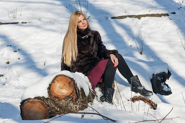 istock Beautiful woman sitting on the log 506755230