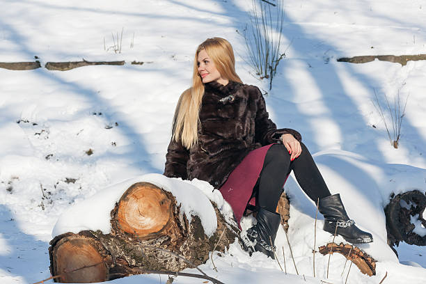 istock Beautiful woman sitting on the log 506755396