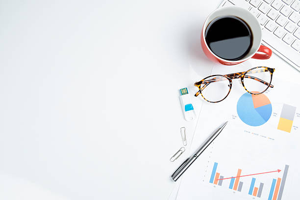 Mix of office supplies and gadgets on a white table. View from above of office supplies and red cup of coffee on a white working table background. wooden flash drive stock pictures, royalty-free photos & images