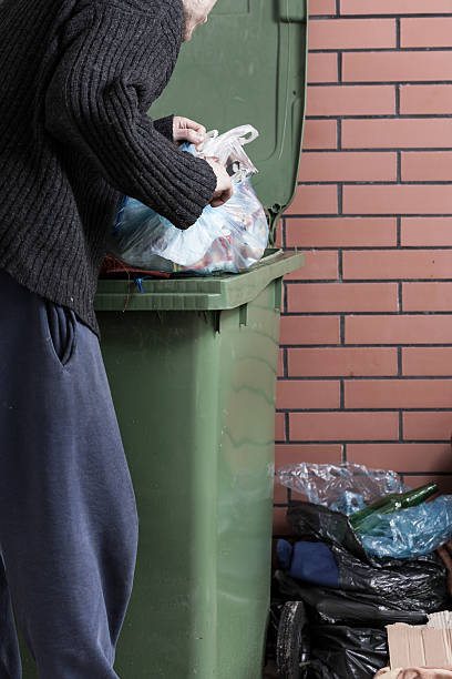 istock Hungry homeless man looking for food in a dumpster 506756907