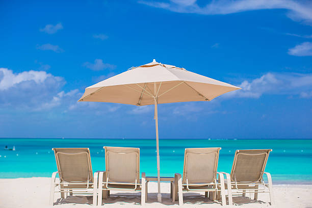 istock White umbrellas and sunbeds at tropical beach 506758193