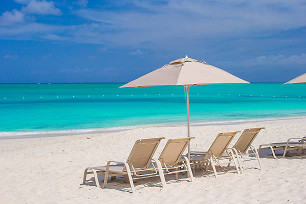 istock White umbrellas and sunbeds at tropical beach 506758197