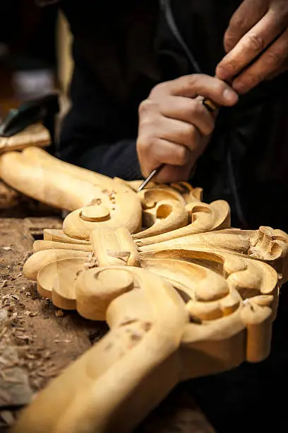 An engraver is carving a wood frame