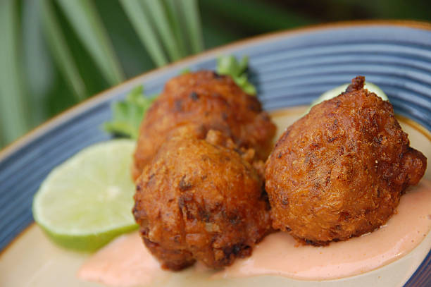 Florida Keys Conch Fritters Three deep fried conch fritters, a specialty of the Florida Keys, served with lime and dipping sauce. fritter photos stock pictures, royalty-free photos & images