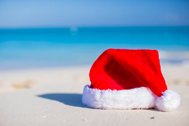 istock Closeup christmas hat on a white sandy beach 506760489
