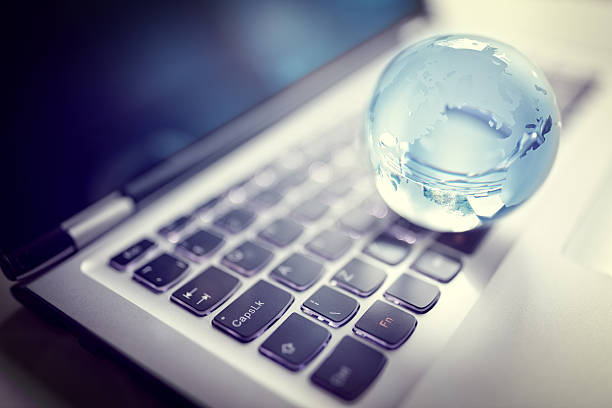 globo de cristal no computador portátil teclado - globe keyboard imagens e fotografias de stock