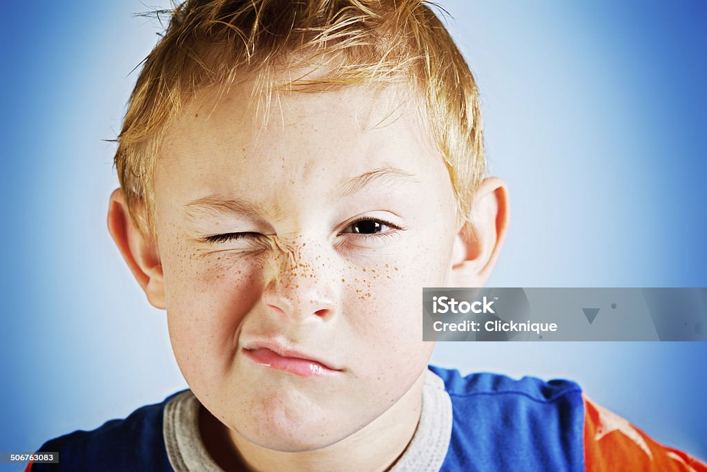 Cheeky freckled toddler boy makes a naughty face Uh-oh, here comes trouble! A freckled, red-haired toddler boy screws up his face, scowling mischievously. He's a handful! 4-5 Years Stock Photo