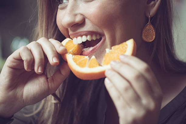 eating оранжевый - beauty in nature women beautiful human teeth стоковые фото и изображения