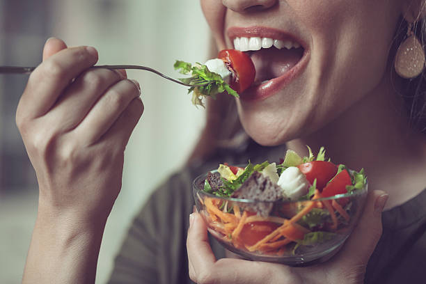 comiendo ensalada - human mouth human teeth indoors young women fotografías e imágenes de stock