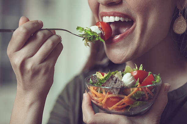 à manger salade - human mouth human teeth indoors young women photos et images de collection
