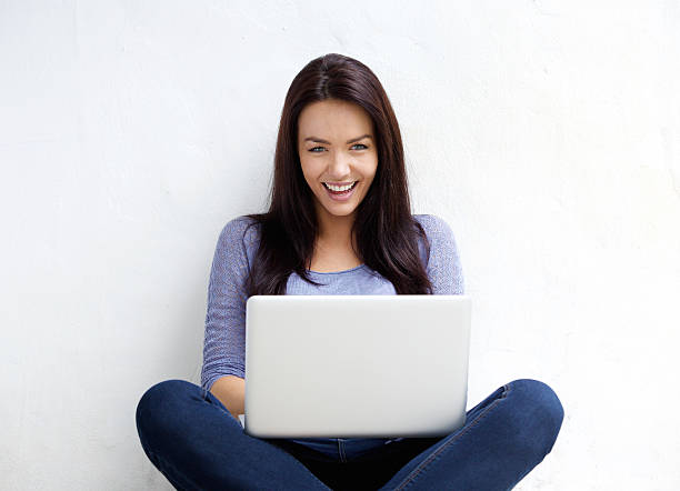 istock Attractive female student smiling with laptop 506764934