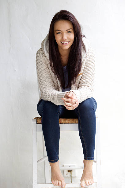 istock Smiling young woman sitting on chair 506765738