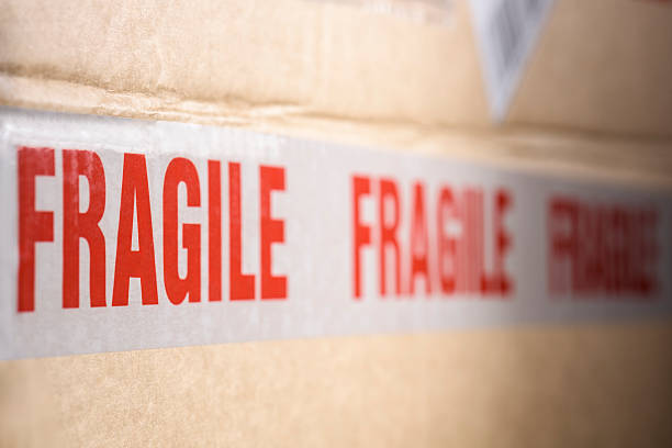 istock Fragile tape wrapped around a brown cardboard delivery box 506766550