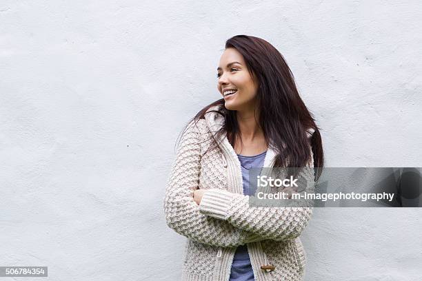 Foto de Mulher Sorridente Em Malha De Lã Branca Em Pé Contra A Parede e mais fotos de stock de Mulheres