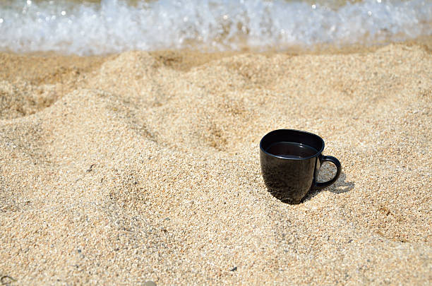 istock Cup of Coffee on Beach 506787460