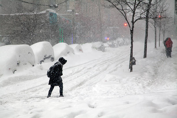 Woman crossing street during snow blizzard Jonas in the Bronx stock photo