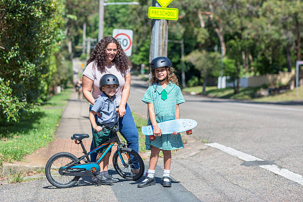 Mum and children crossing the road to school Aboriginal family going to school indegious culture stock pictures, royalty-free photos & images