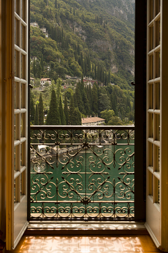 View out to Lake Como through a window door balcony in Varenna, Italy. 