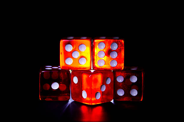 red dice to against light with black background photography of red dice against light with black background. ganar stock pictures, royalty-free photos & images