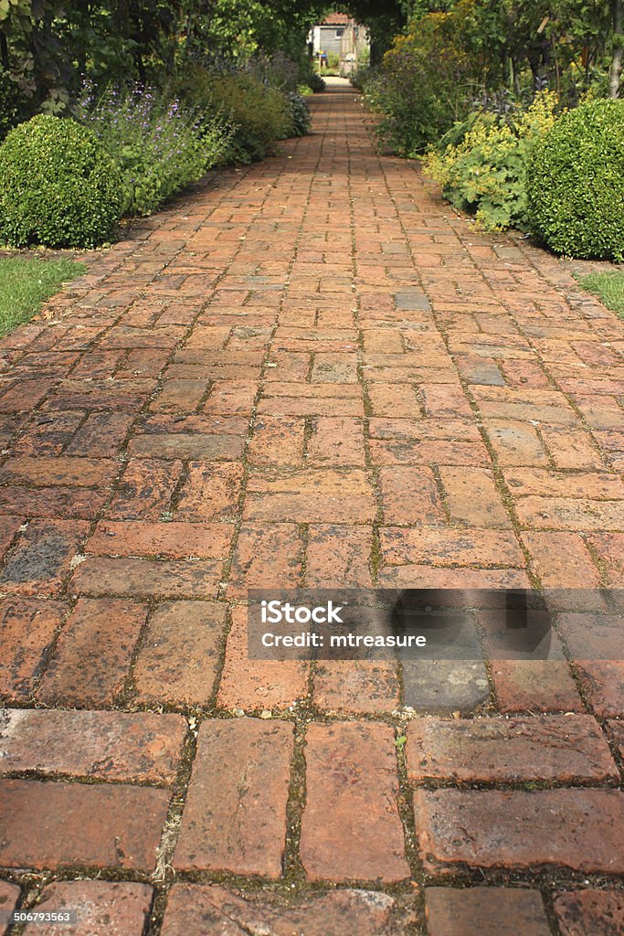 Image of old red brick path, block paving, paved pathway Photo showing an old block paved pathway, with weathered / aged red bricks that are full of character.  The bricks in this path have been laid out in a traditional alternating 'basketweave' pattern, with the simple footpath leading through the lawn and garden. Block Shape Stock Photo