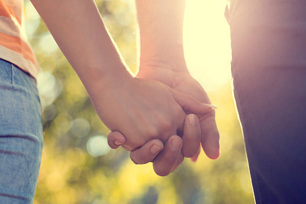 istock Young couple holding hands in park 506794232